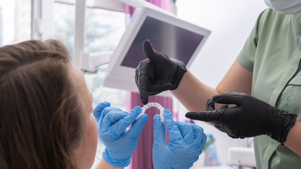 Guantes sanitarios. Aparecen dos especialistas intercambiando opiniones sobre una férula.