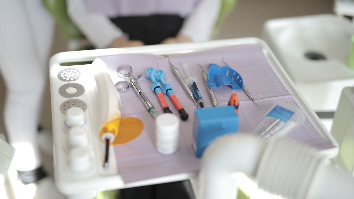Eliminación desechos clínica dental. Aparecen diferentes instrumentos para realizar una limpieza en una bandeja.