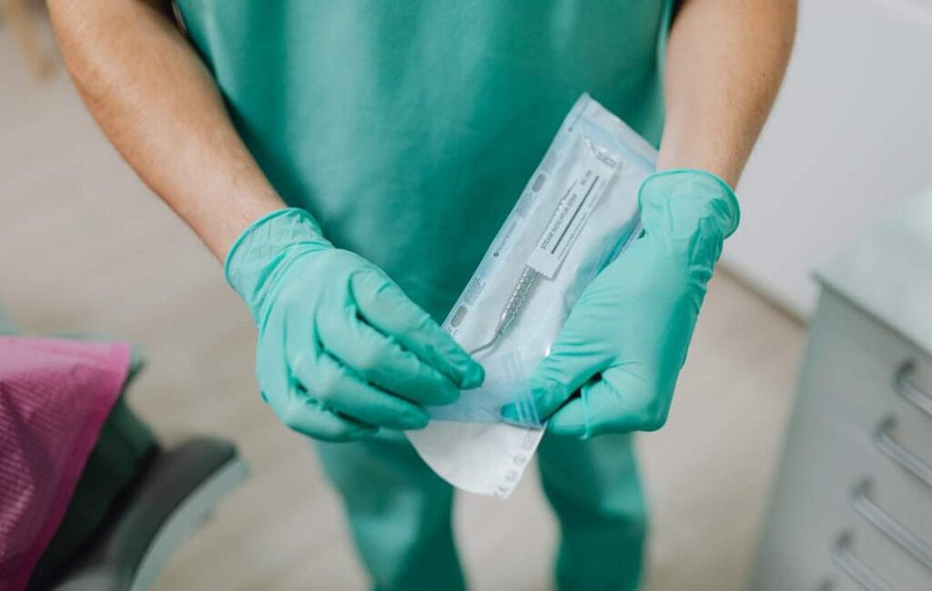 manos con guantes de nitrilo manipulando material médico estéril para explicar para qué se usan los guantes de nitrilo